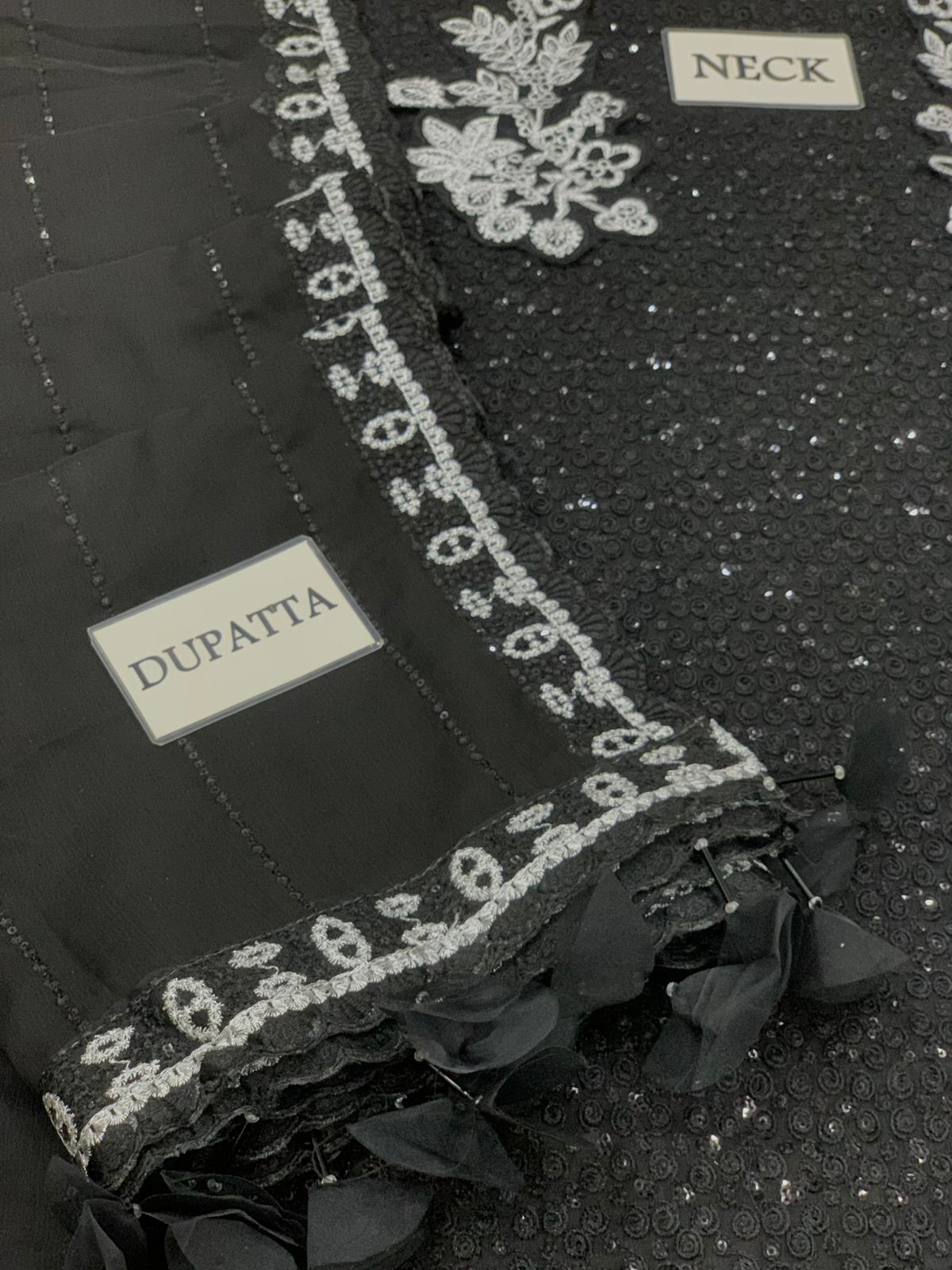 Black dupatta with silver embroidery and text on a dark background