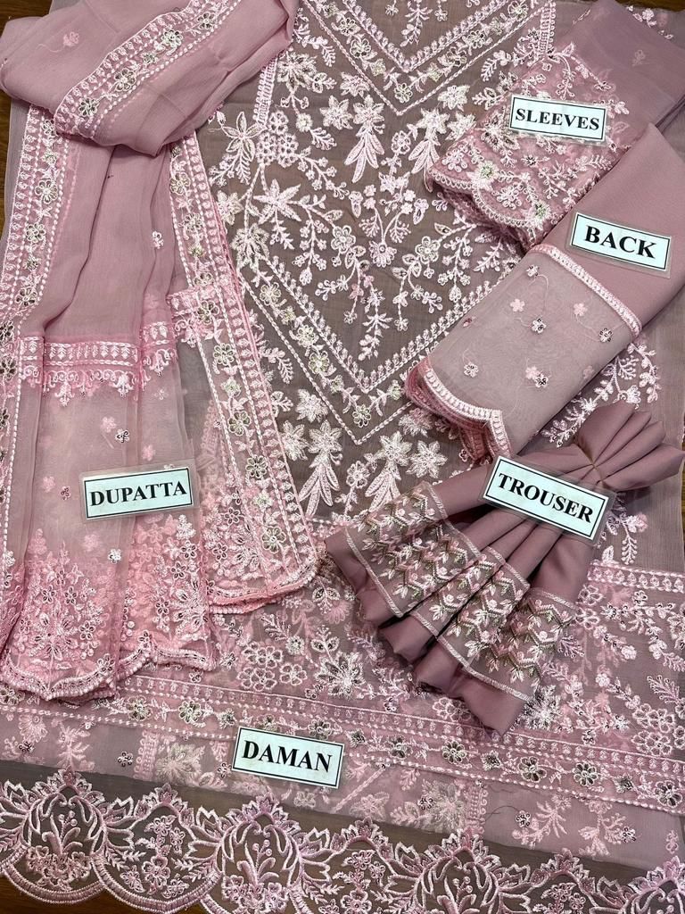 Pink embroidered fabric set with labeled parts on a matching fabric background