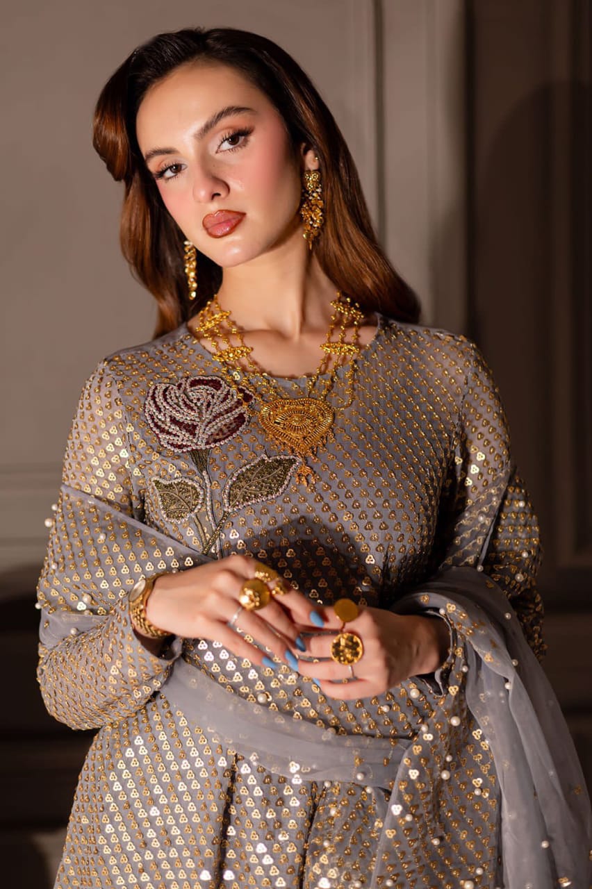 Nure Midnight Wedding & paRTY wEAR Woman in a sparkling outfit with gold jewelry against a neutral background