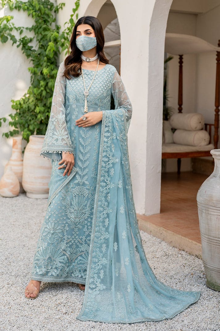 Flossie Blossom Sky Dress in a light blue embroidered traditional outfit standing in an outdoor setting.