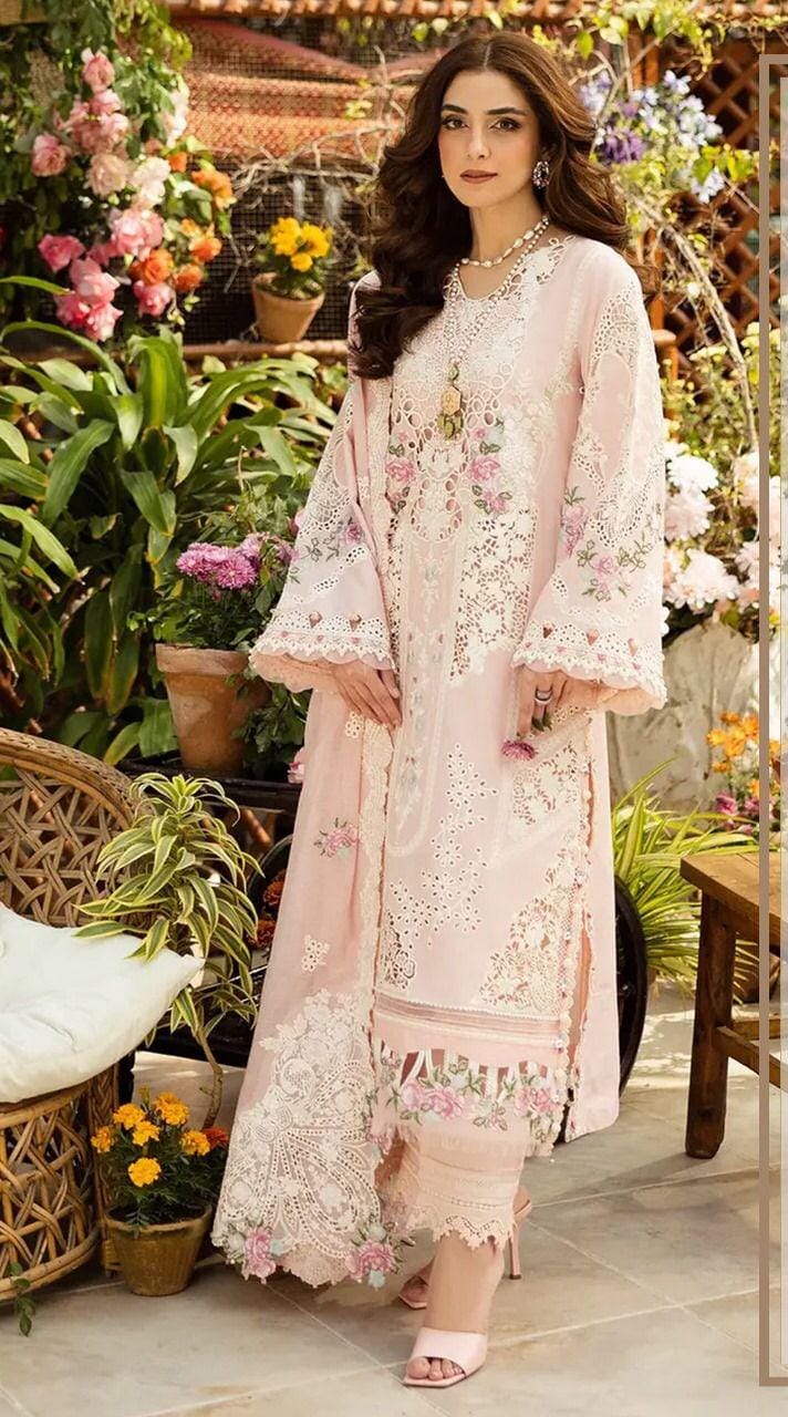 Elaaf Chikankari Pink in a floral dress standing in a garden with flowers and plants.