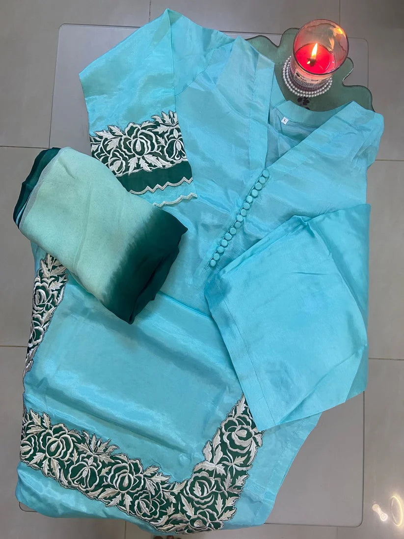 Turquoise saree with green blouse on a white surface
