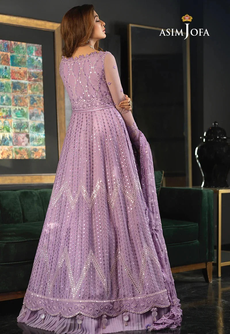 Asim Jofa Maxi Most BEautiful Purple  wearing a purple embroidered dress in a room with green furniture and a painting.