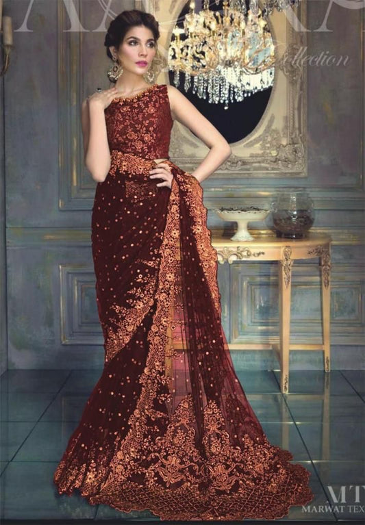 A woman models a deep maroon sequined evening gown with a matching dupatta in an ornate room with a chandelier and gold console table.