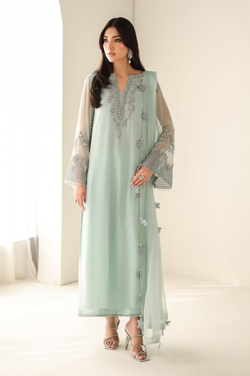 Ferozi wearing a light green embroidered outfit with a matching dupatta on a white background