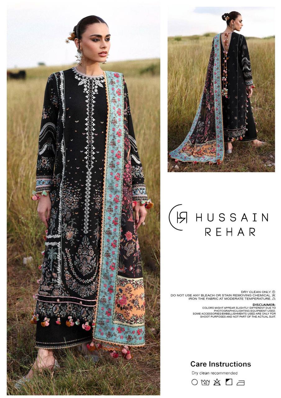 Woman wearing a black and white patterned dress with a floral dupatta in a grassy field, with 'Hussain Rehar' branding.