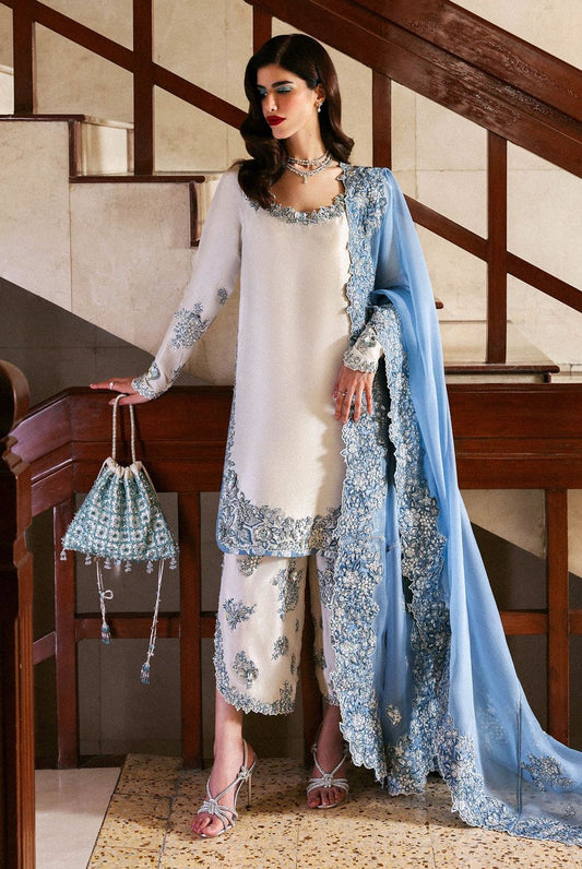 Hussain Rehar Wz-02 Sheesha Silk Heavy Adda Work With Clutch 2025l outfit with white and blue embroidered attire standing on a staircase.