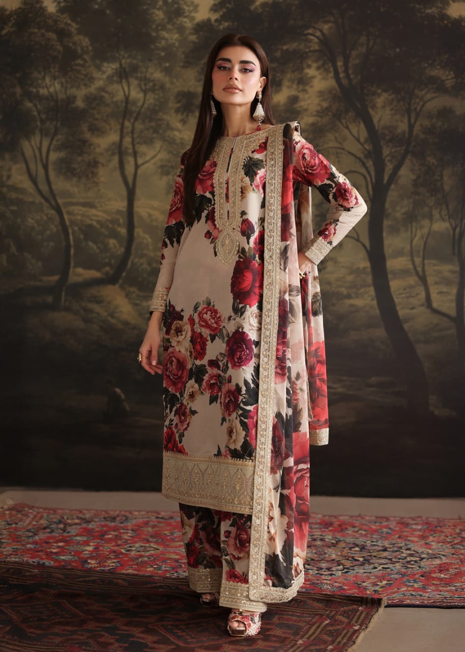 Woman in a floral dress with a matching dupatta standing against a painted landscape background.