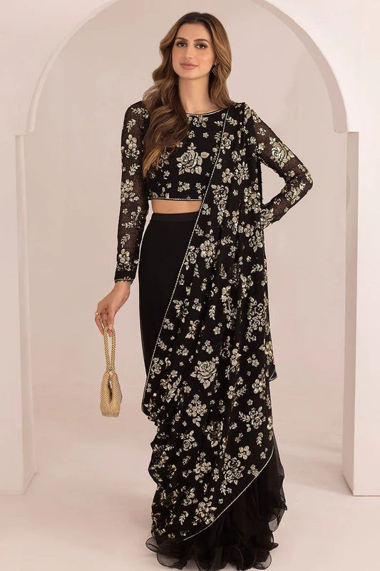 Woman wearing a black floral saree with a white background