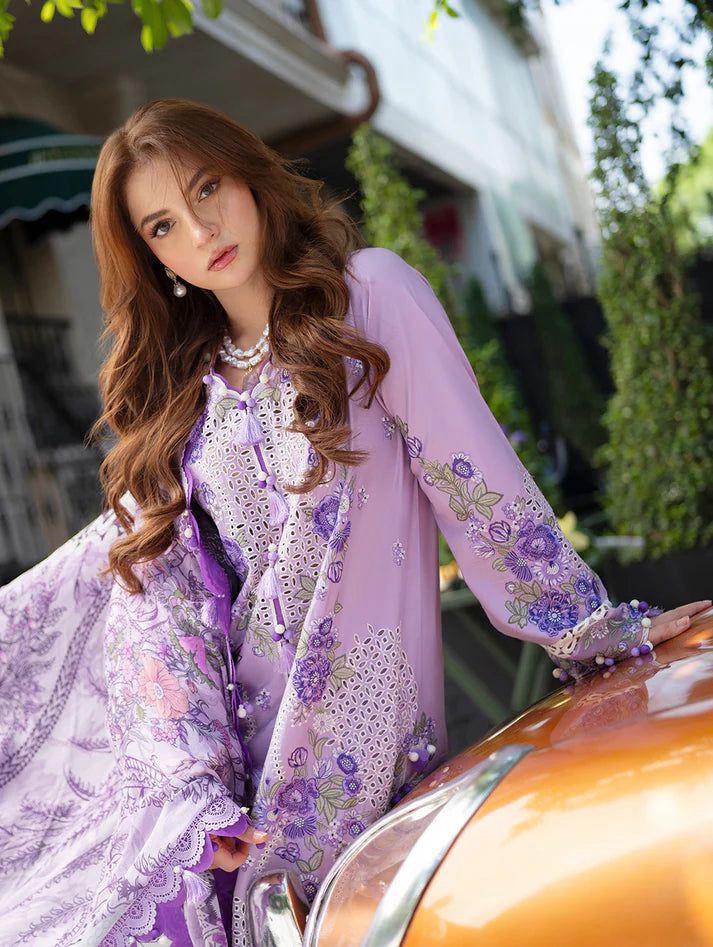 Woman in a purple floral outfit sitting on a car with a blurred background