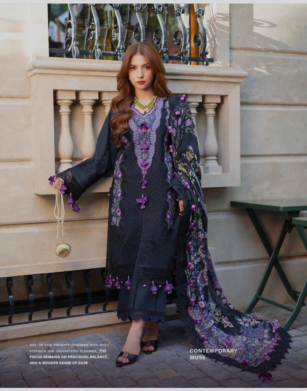 Jade black purple Ombre Dananeer embroidered outfit standing outdoors with a decorative background.