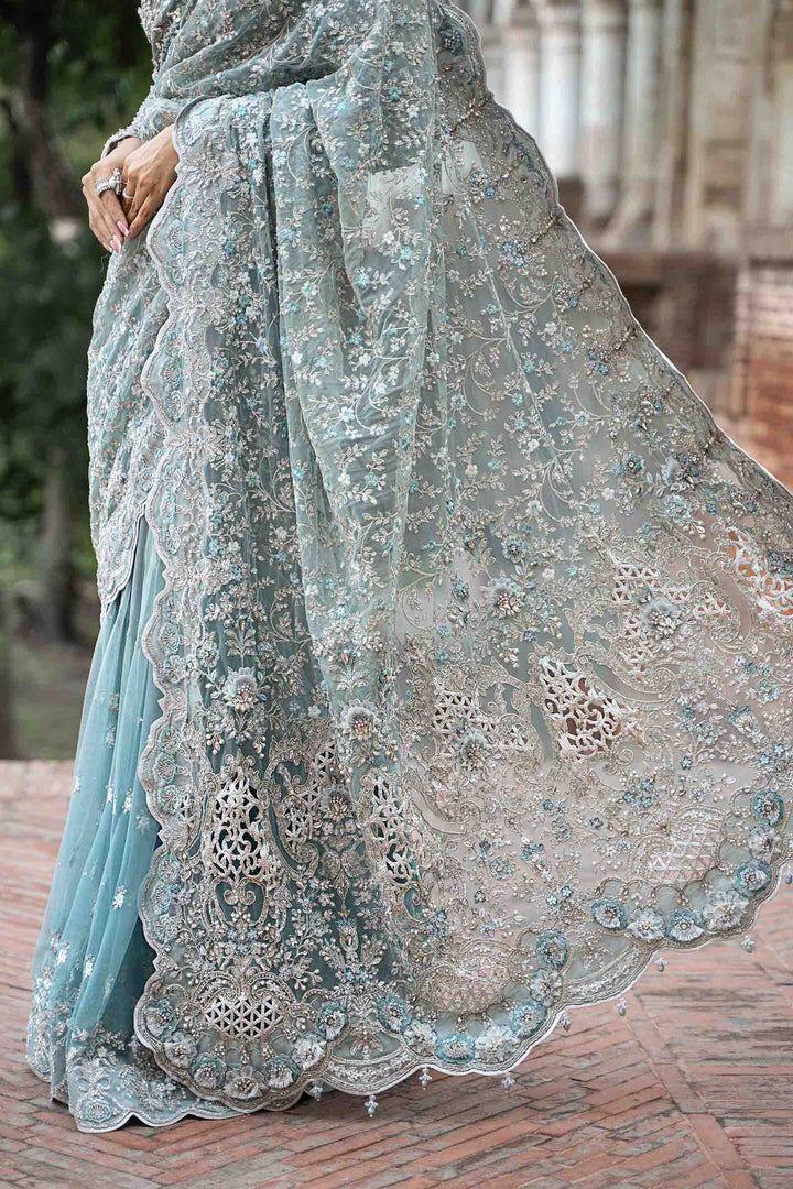 Light blue embroidered saree with intricate patterns on a brick surface