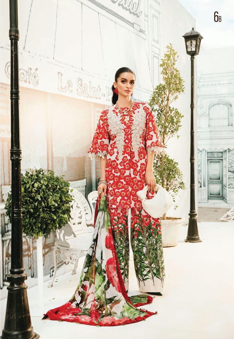 Woman in a red and white floral dress standing in an elegant outdoor setting with classical architecture.