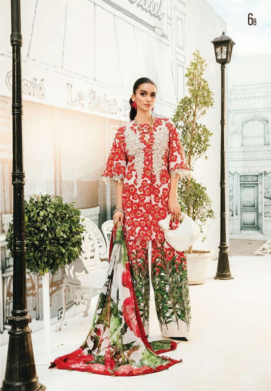 Woman in a red and white floral dress standing in an elegant outdoor setting with classical architecture.