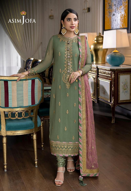 Woman in a green and pink traditional outfit with 'Asim Jofa' branding in an elegant room.
