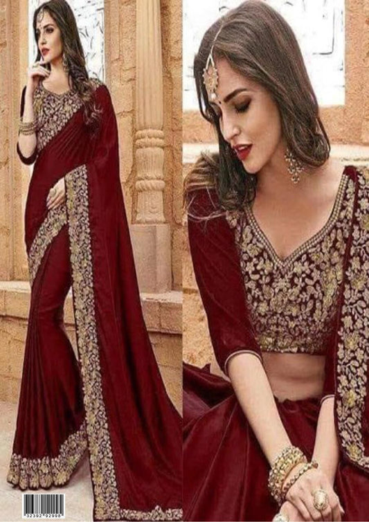 Woman wearing a maroon saree with gold embroidery in an outdoor setting.