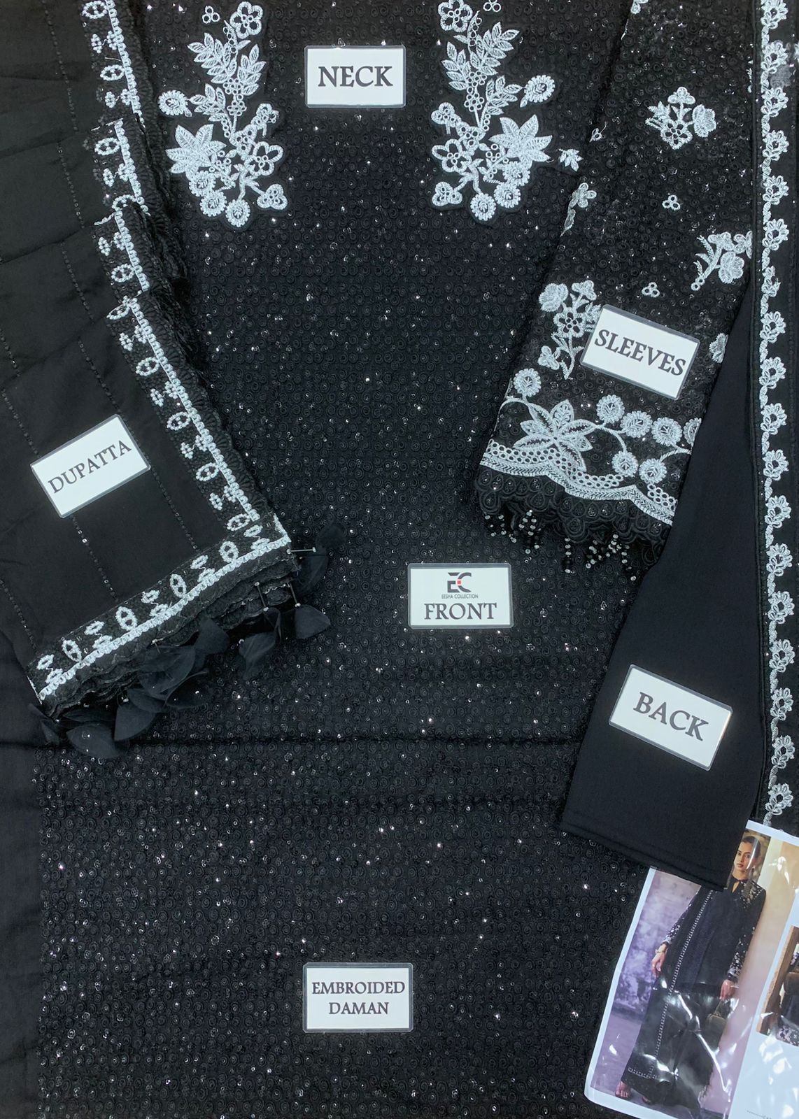 Black embroidered garment with labeled sections on a white background