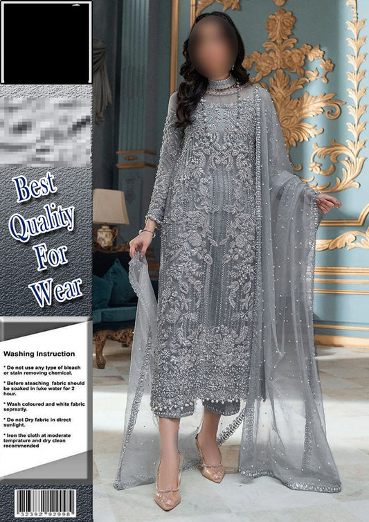Woman wearing a silver embroidered dress with a sheer overlay in a decorated room.