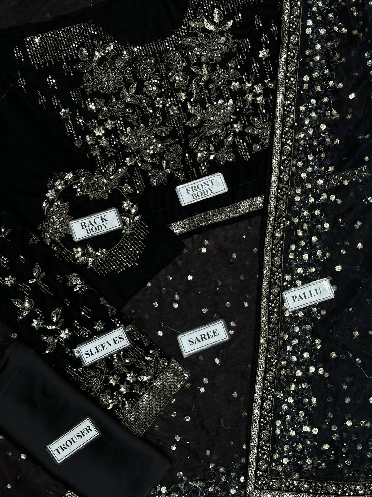 Black dress with silver embellishments and labeled parts on a black background