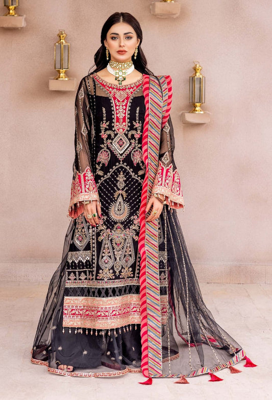 Adan Libas Bridal Woman wearing a traditional embroidered outfit with a red and gold scarf against a neutral background
