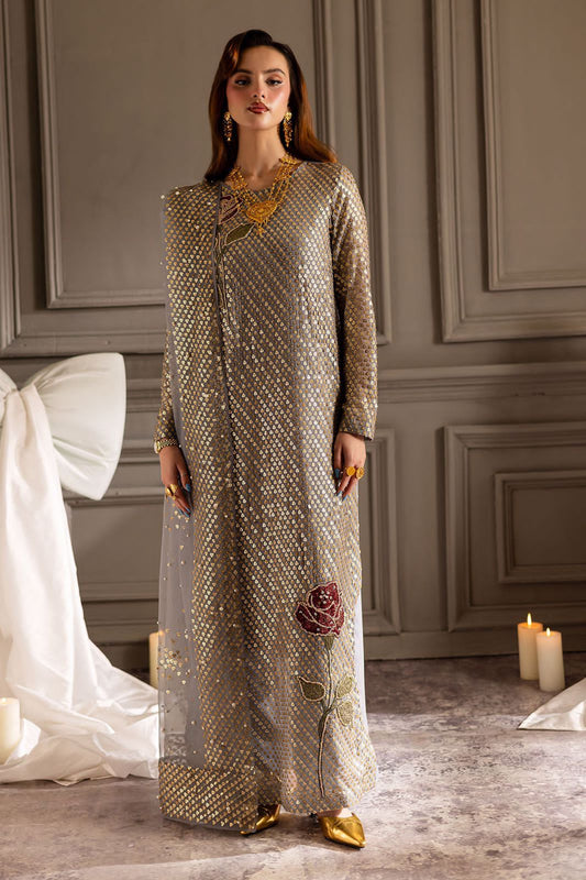 Nure Midnight paRTY wEAR Woman in a long, patterned dress with gold accents standing in a room with gray walls and white curtains.