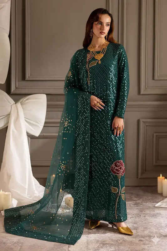 Woman in a green traditional outfit with floral patterns in a decorated room.