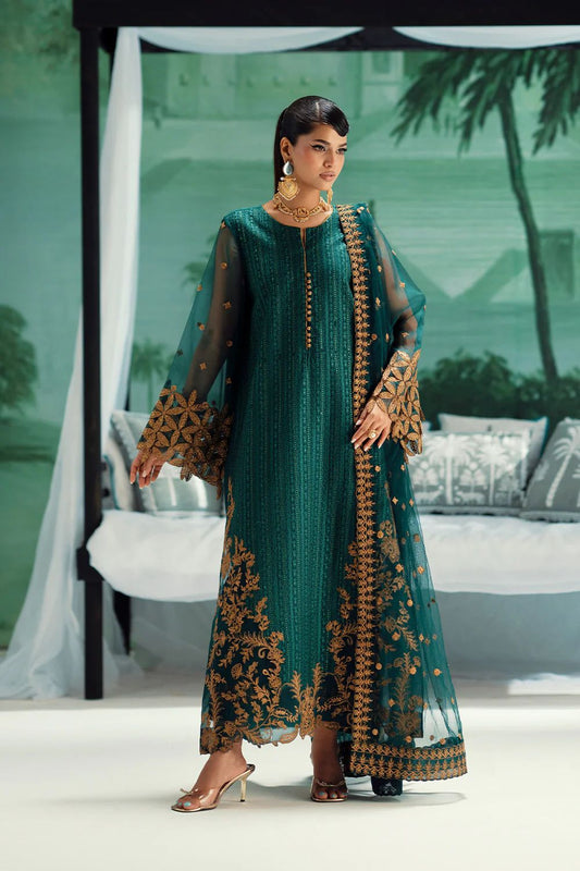 Maryam n Maria Dark Green Kai COlor Dress Formal in a teal and gold embroidered dress standing in an outdoor setting.