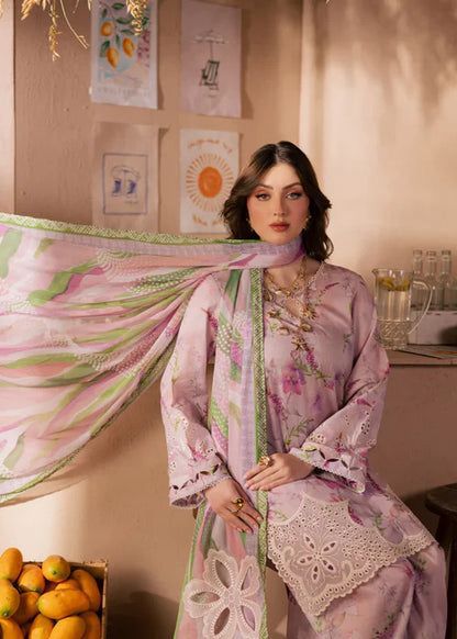Woman in a pink floral dress holding a matching dupatta in a room with decor elements.