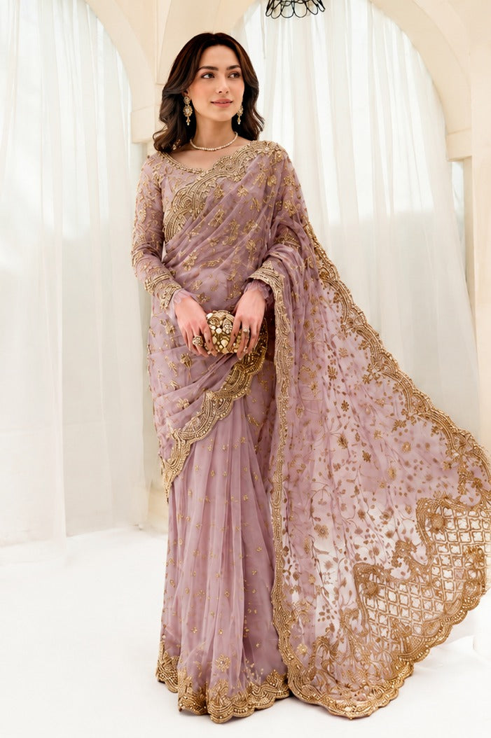 A woman models a lavender purple and gold heavily embroidered traditional Indian saree in a bright, white-walled room with arches.